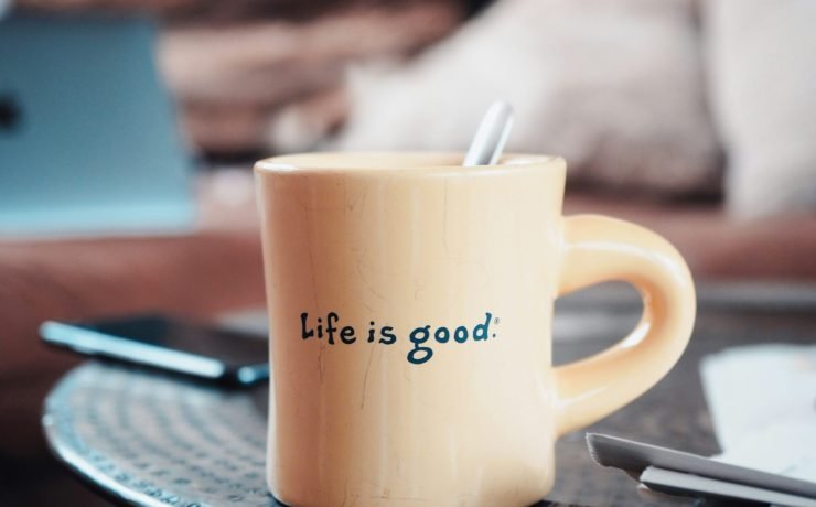 brown ceramic mug on blue and white ceramic plate